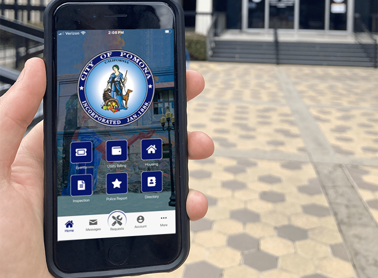 Pomona Go App Home Screen on a mobile phone showcased in front of city hall