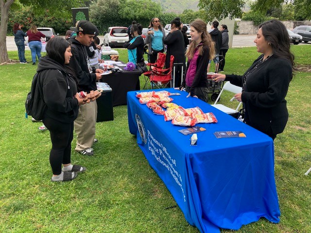 office of violence prevention staff spreading awareness at the park with pamphlets and food