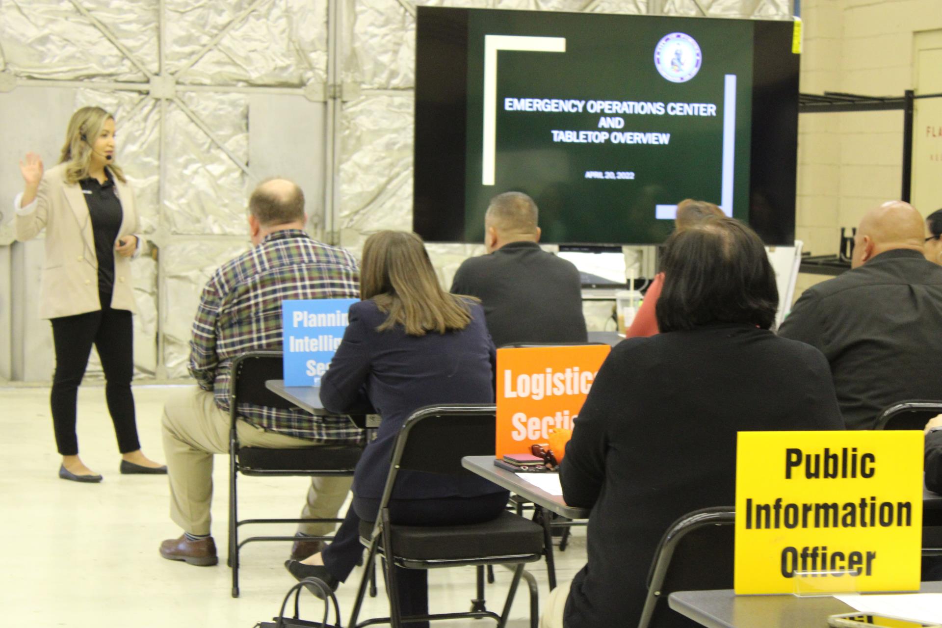 People sitting at tables listening the meeting. Each in their designated roles