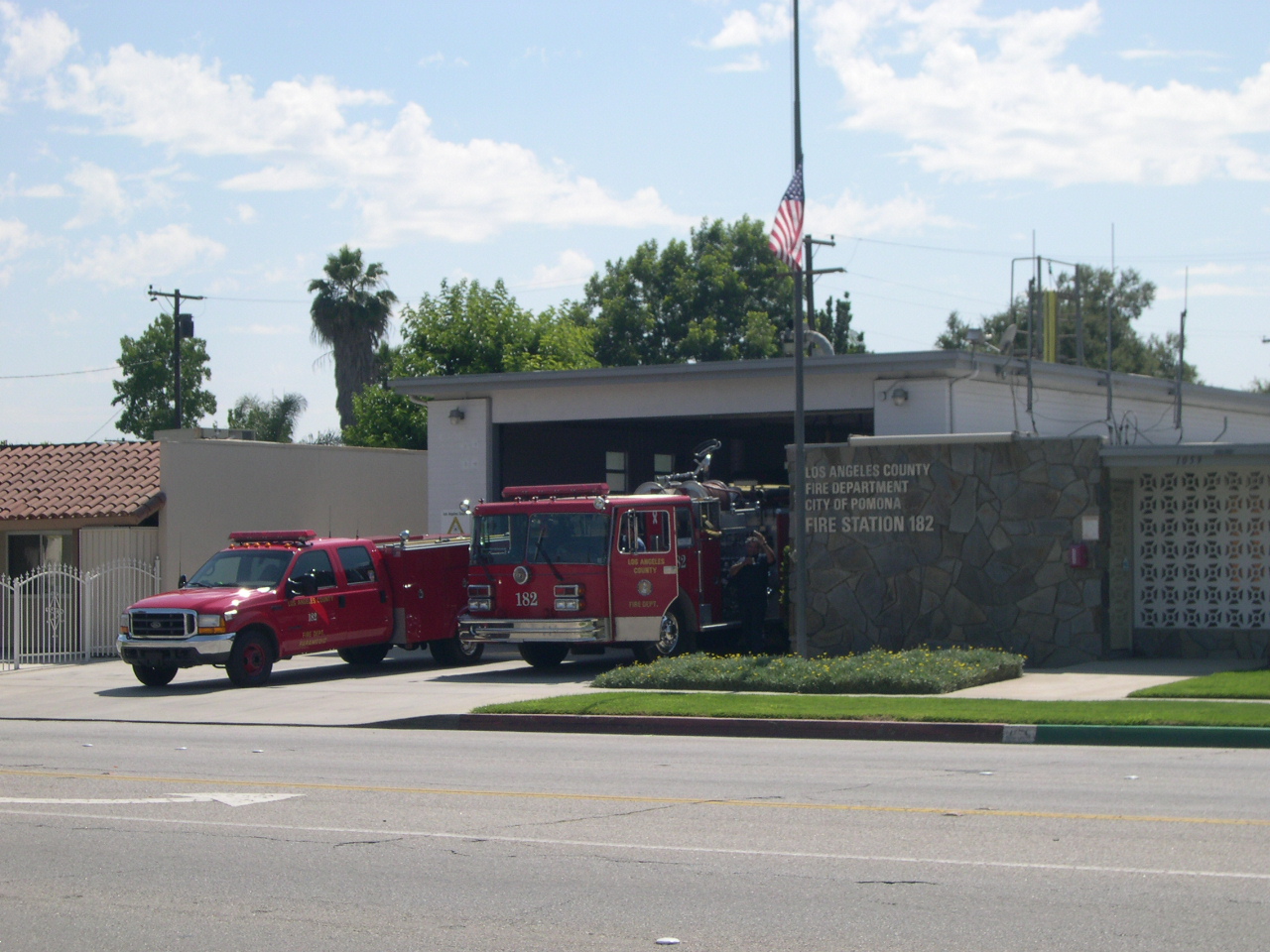 Firetruck 182 and ford truck parked side by side in Fire Station. 