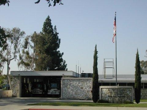 2 firetrucks parked inside of their 186 station. Concrete marbling of the fire station structure surrounds them. 